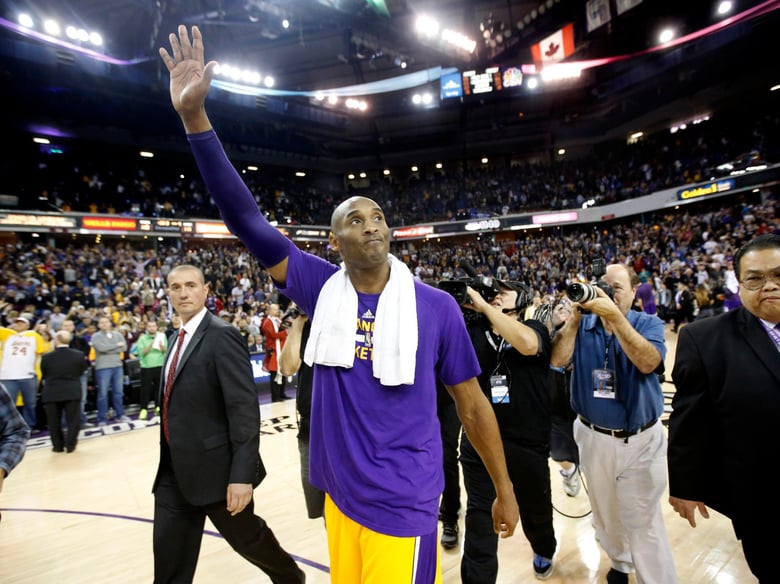 Former Laker Kobe Bryant waves to the crowd during his jersey